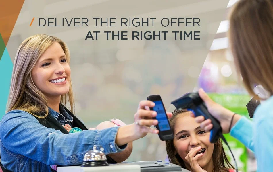 Woman and child at checkout scanning phone